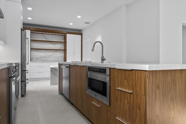 kitchen featuring stainless steel appliances, sink, and white cabinets