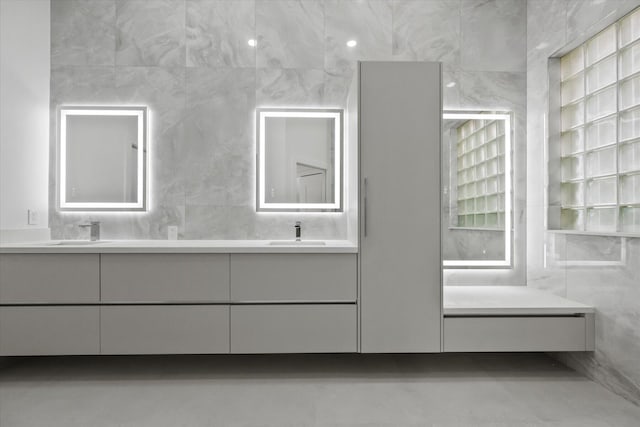 bathroom with vanity and tile walls