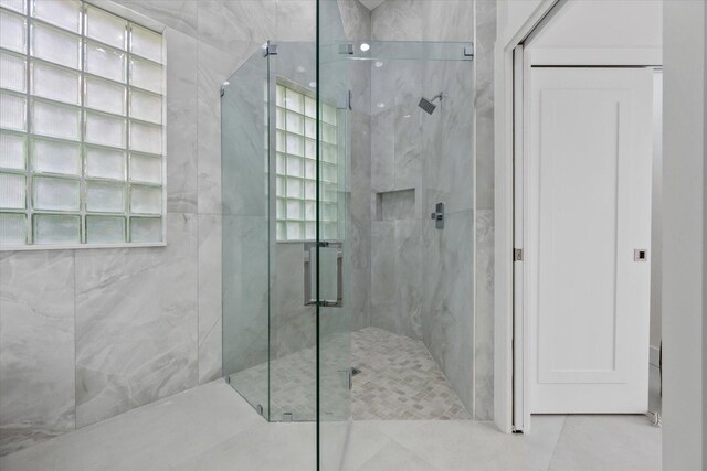 bathroom with an enclosed shower and tile patterned flooring