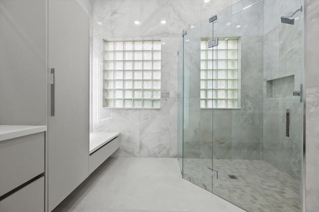 bathroom featuring vanity, tile walls, and walk in shower