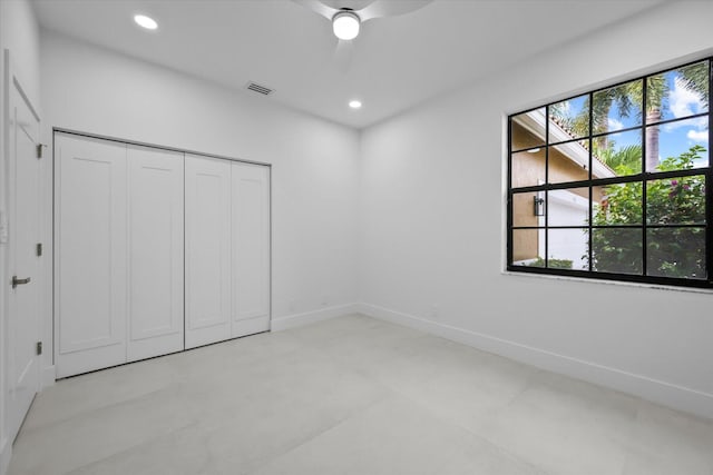 unfurnished bedroom featuring multiple windows, ceiling fan, and a closet