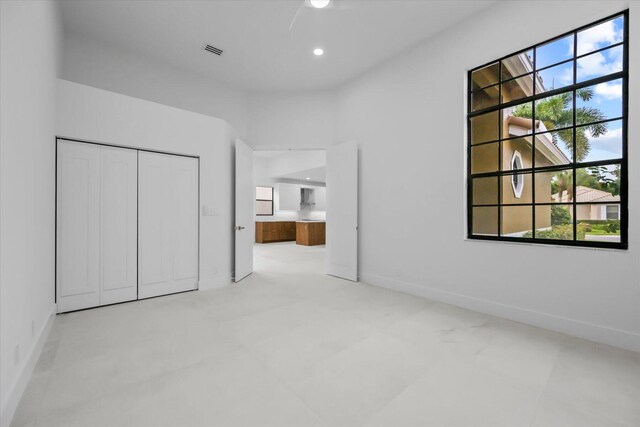 unfurnished bedroom featuring a closet and multiple windows