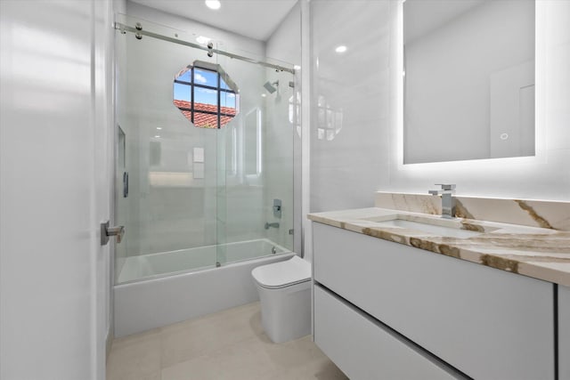 full bathroom featuring enclosed tub / shower combo, vanity, tile patterned floors, and toilet