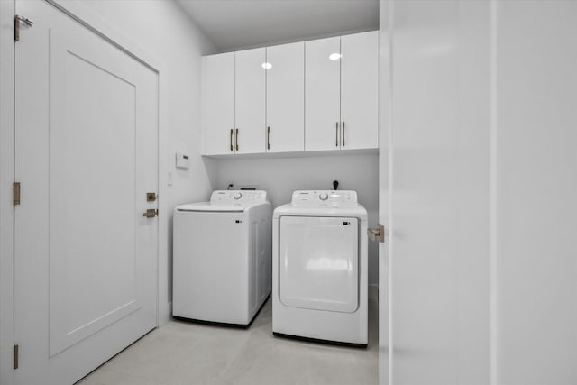 washroom featuring cabinets and separate washer and dryer