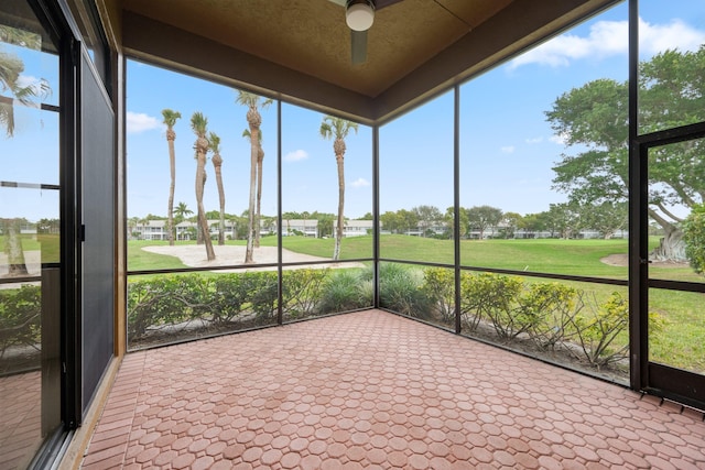 unfurnished sunroom featuring ceiling fan