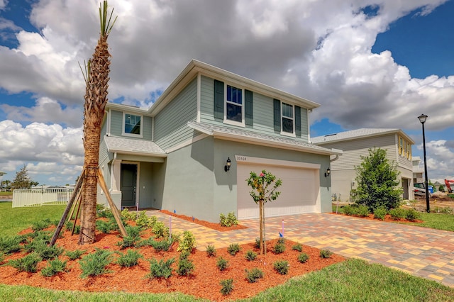 front of property featuring central AC, a garage, and a front lawn