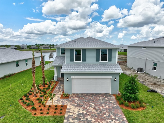 view of front of property featuring central air condition unit, a front lawn, and a garage