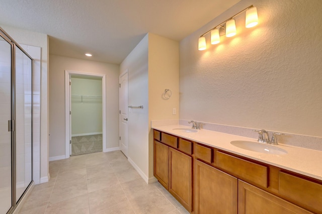 bathroom with tile patterned flooring, vanity, and a shower with shower door