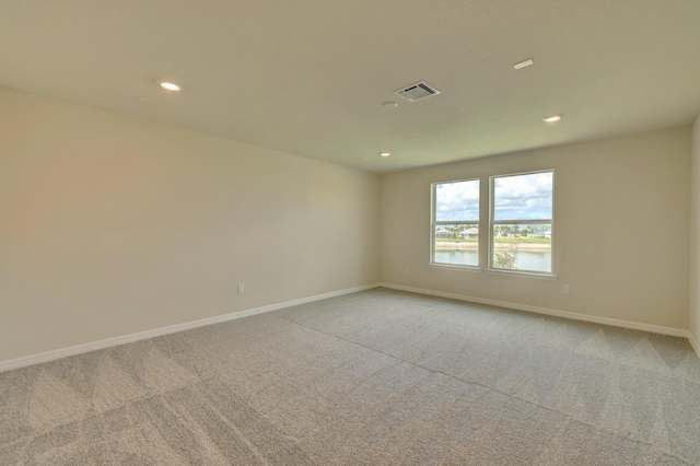 unfurnished room featuring carpet flooring and a water view