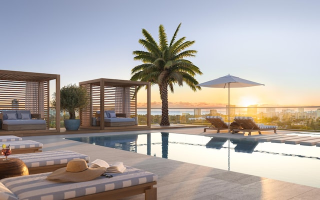 pool at dusk featuring a water view and a community pool