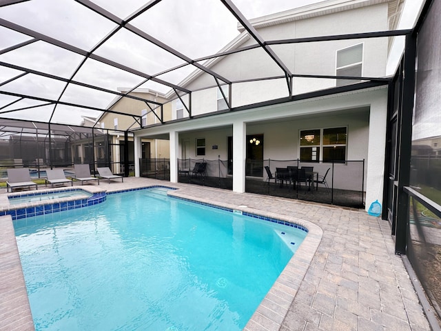 view of pool featuring an in ground hot tub, a lanai, and a patio area