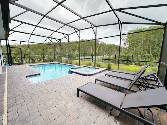 view of swimming pool with an in ground hot tub, a patio area, and a lanai