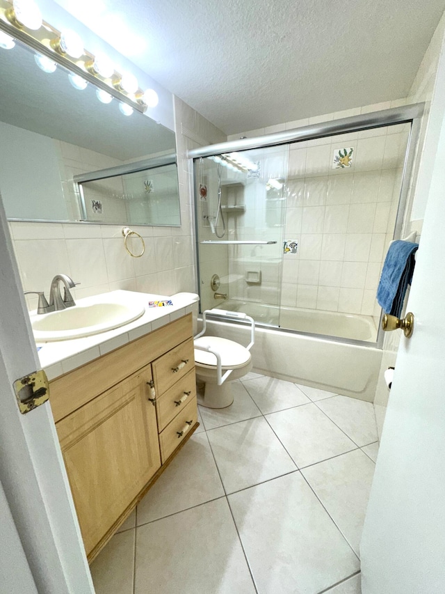 full bathroom featuring vanity, tile walls, enclosed tub / shower combo, and tile patterned flooring