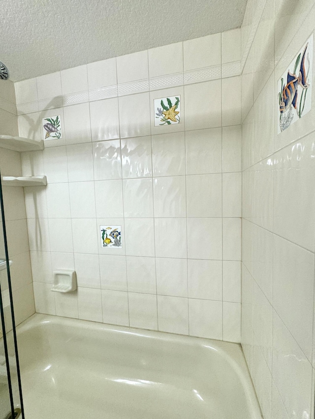 bathroom featuring tiled shower / bath and a textured ceiling