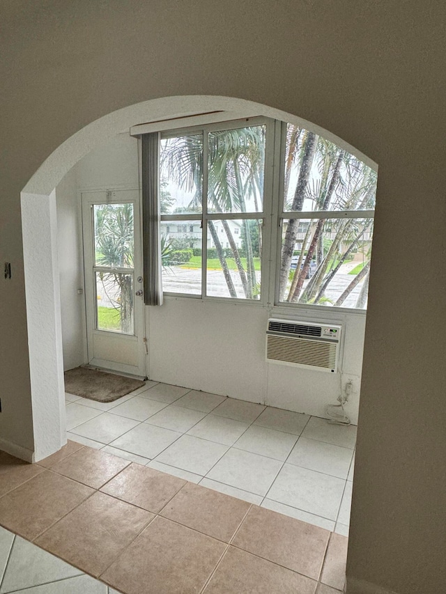 interior space featuring light tile patterned flooring and a wall mounted AC