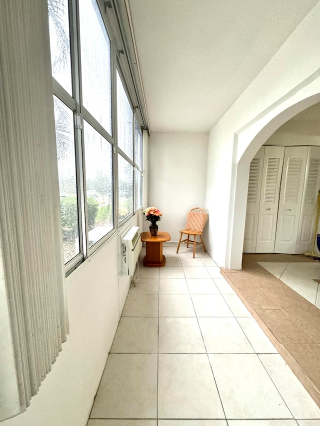 unfurnished sunroom with a wall unit AC