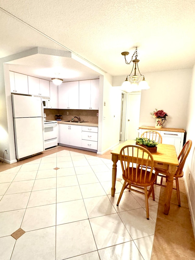 kitchen with tasteful backsplash, white appliances, light tile patterned floors, white cabinets, and pendant lighting