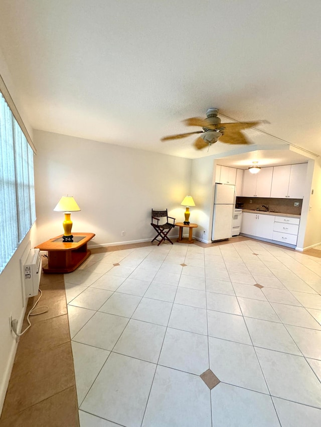 unfurnished room with light tile patterned flooring, sink, and ceiling fan