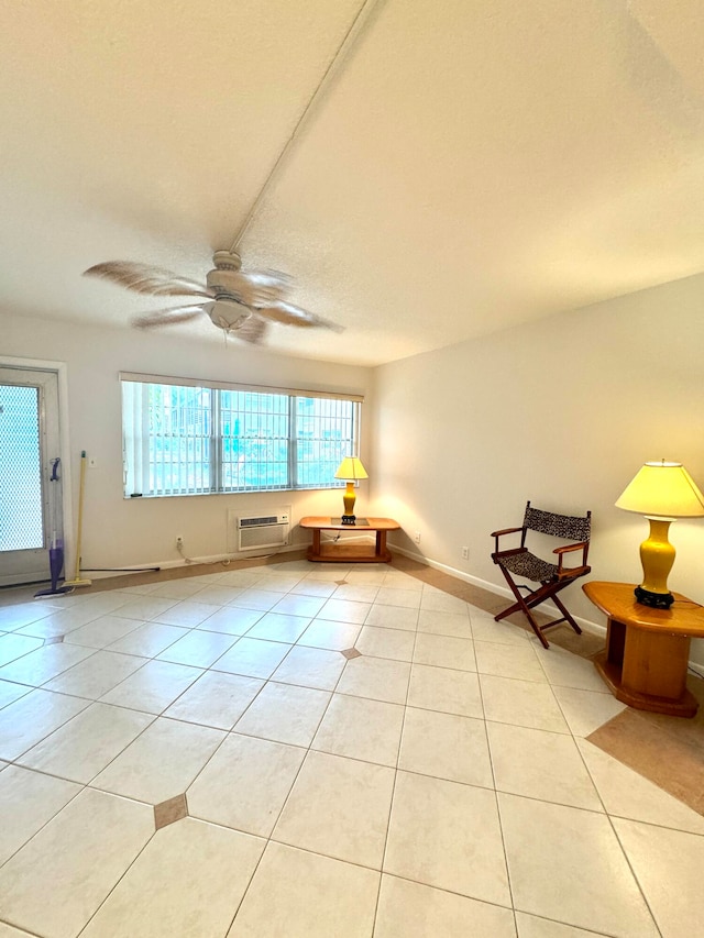 interior space with light tile patterned flooring, a wall mounted air conditioner, and ceiling fan