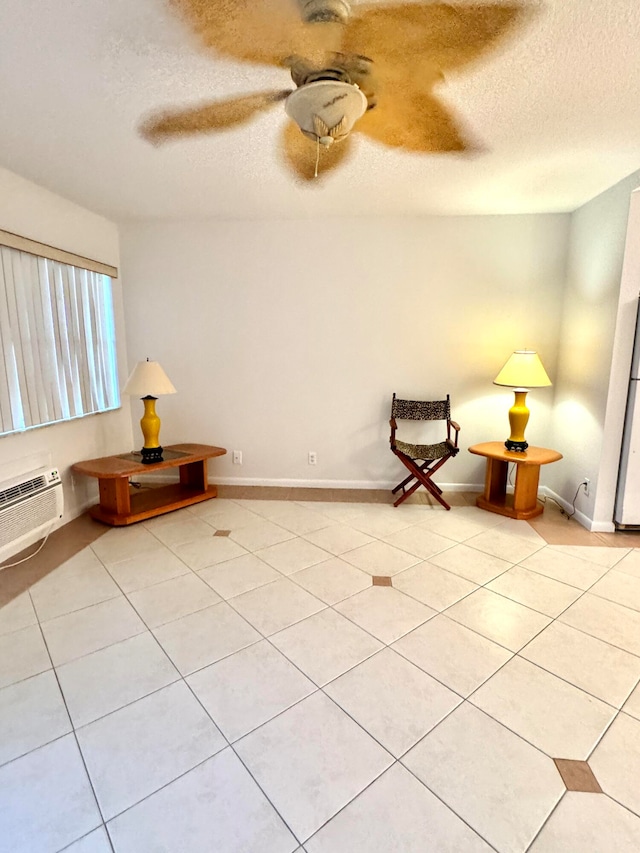 unfurnished room featuring light tile patterned flooring, a textured ceiling, a wall unit AC, and ceiling fan