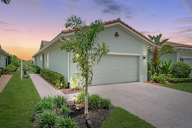 mediterranean / spanish-style home with a yard and a garage