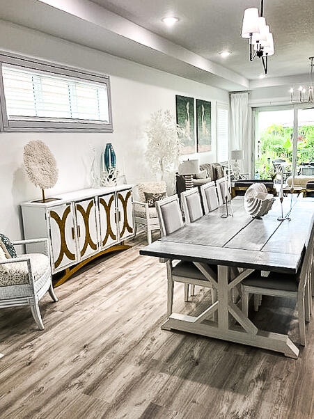 dining area featuring a tray ceiling, a chandelier, and hardwood / wood-style flooring