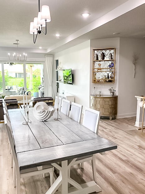 dining space with light wood-type flooring and a notable chandelier