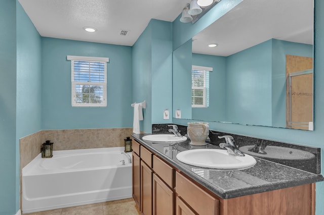 bathroom featuring vanity, a textured ceiling, tile patterned floors, and plus walk in shower