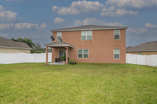 rear view of house featuring a yard