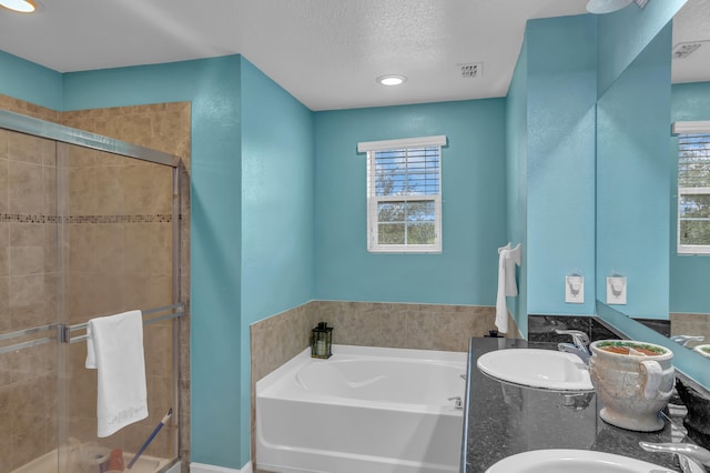 bathroom featuring vanity, shower with separate bathtub, and a textured ceiling