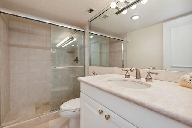 bathroom with a shower with shower door, oversized vanity, toilet, and tile floors