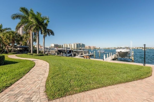 surrounding community with a lawn, a water view, and a dock