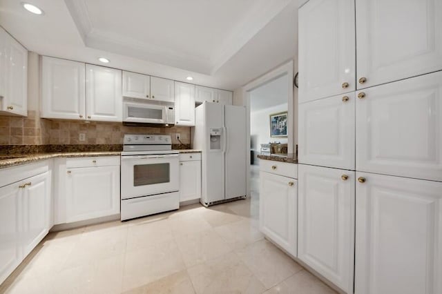 kitchen with white cabinetry, a tray ceiling, white appliances, and tasteful backsplash