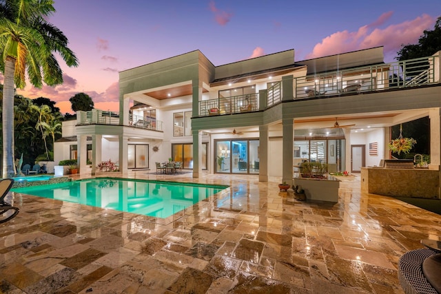 pool at dusk with a patio area