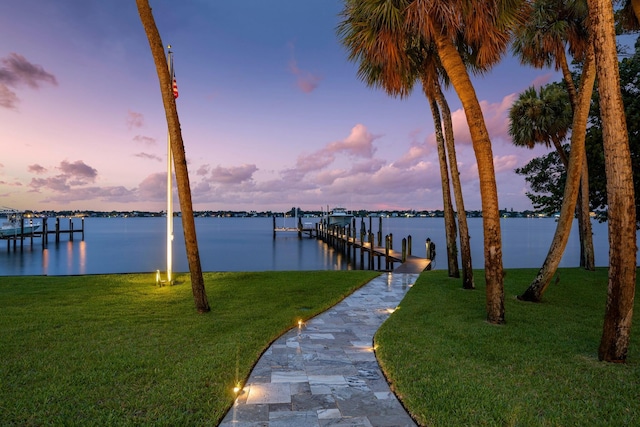 dock area with a lawn and a water view