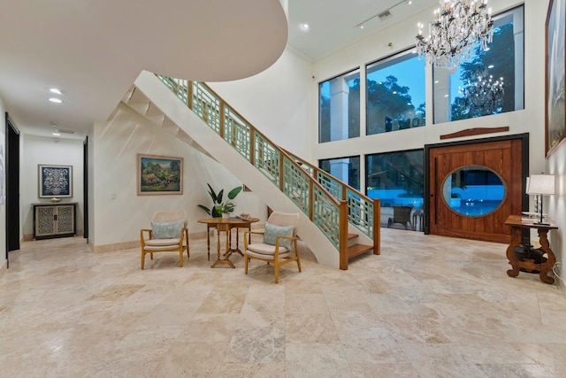 stairway featuring a notable chandelier and a towering ceiling