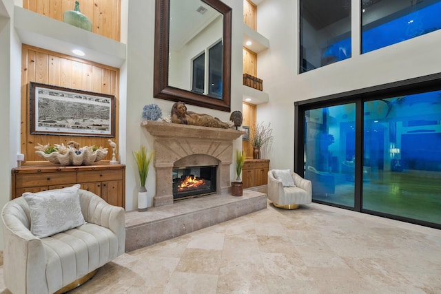 sitting room featuring a towering ceiling and a fireplace