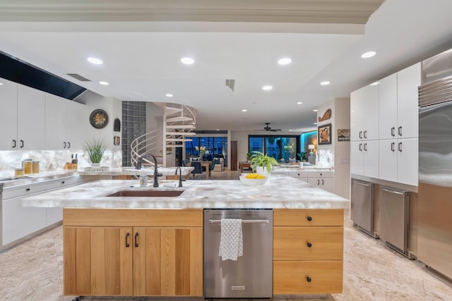 kitchen featuring white cabinets, ceiling fan, sink, and a kitchen island with sink