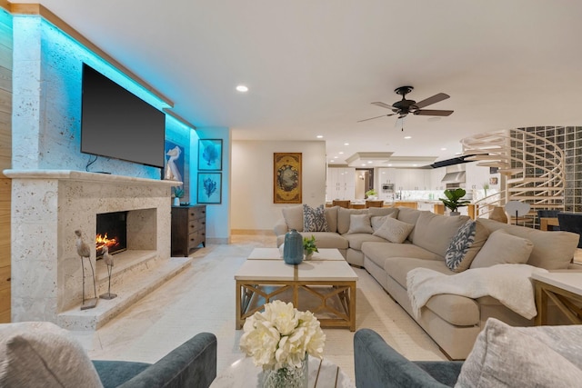 living room featuring a high end fireplace and ceiling fan