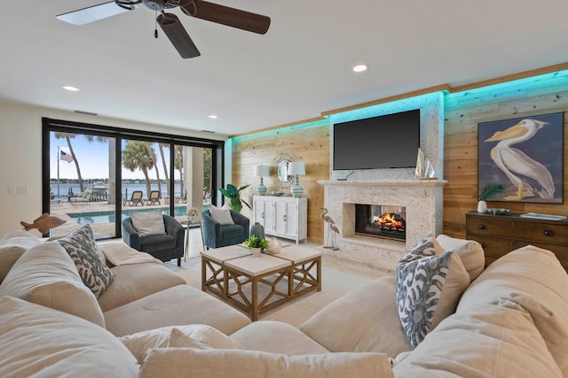 living room featuring ceiling fan, wood walls, and a multi sided fireplace