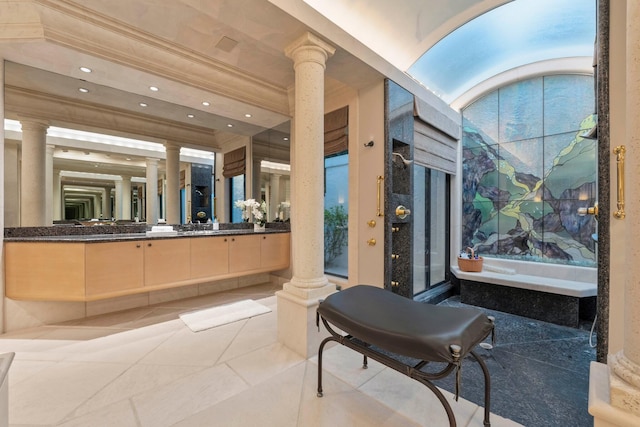 bathroom with decorative columns, a tub, crown molding, and vanity