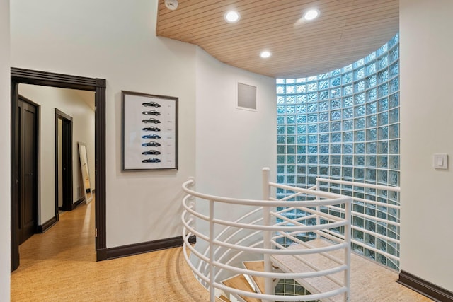 hall featuring a healthy amount of sunlight, expansive windows, and wood ceiling