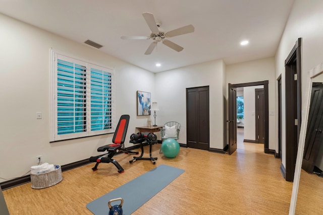 workout room with ceiling fan and light hardwood / wood-style floors