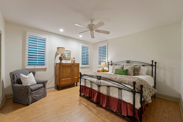 bedroom with a textured ceiling, light hardwood / wood-style flooring, and ceiling fan