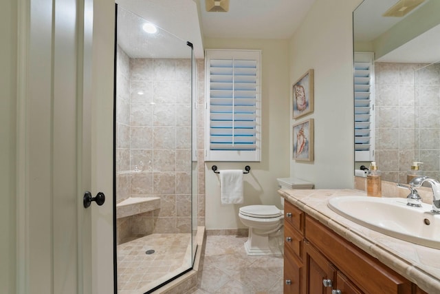 bathroom with tile patterned floors, vanity, toilet, and a shower with shower door