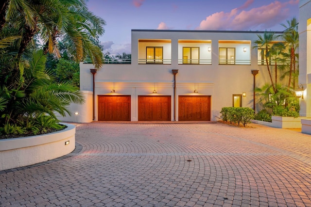 view of front of home with a garage and a balcony