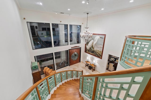 stairway featuring a chandelier and ornamental molding