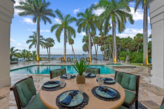 view of pool featuring a patio area, an in ground hot tub, and a water view