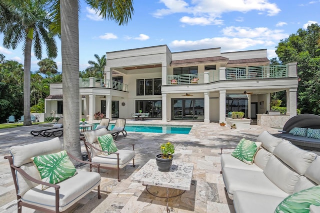 back of property featuring outdoor lounge area, a patio area, and a balcony