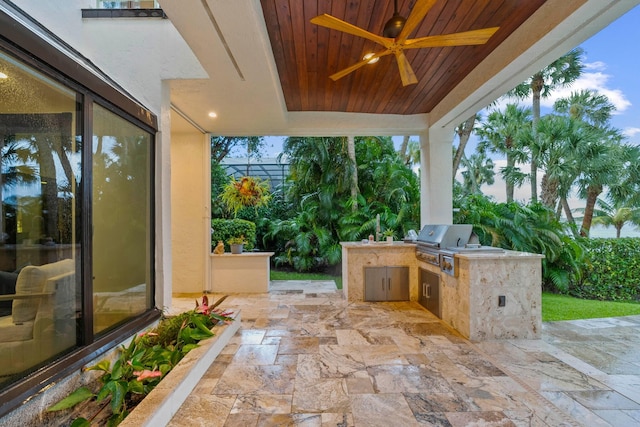 view of patio / terrace with area for grilling, ceiling fan, and exterior kitchen